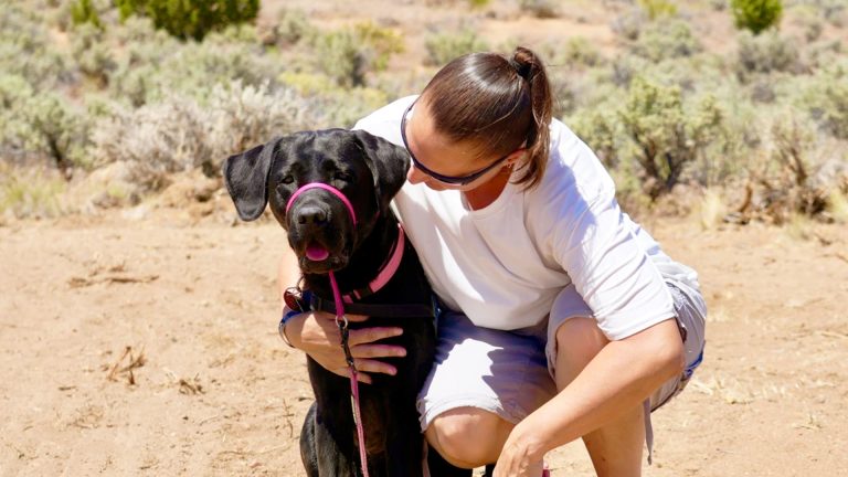 Eryn Redmon Steed, a Veteran and puppy raiser with Liberty Dogs, holds her black labrador Annie