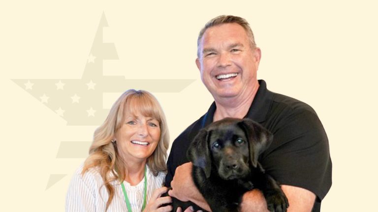 City of Sparks council member Paul Anderson and his wife hold Parks, a Liberty Dogs puppy